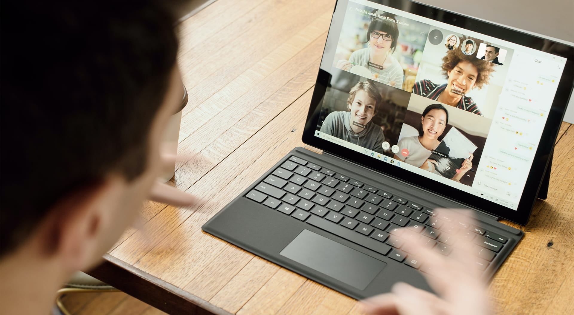 En man har ett videomöte med fyra andra personer.