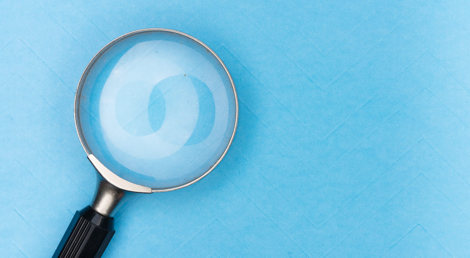 Ett förstoringsglas mot blå bakgrund